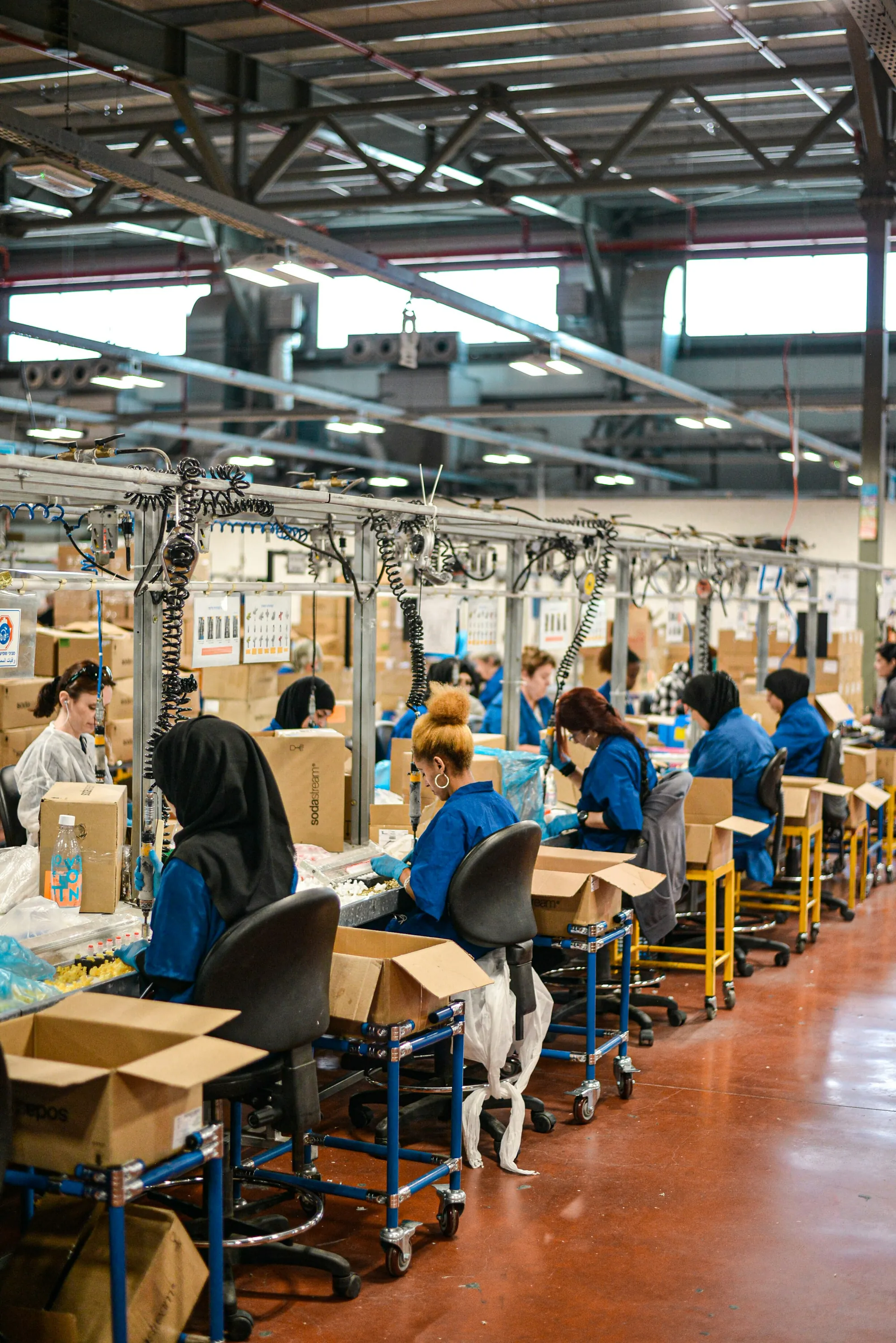 Workers on a long factory assembly line
