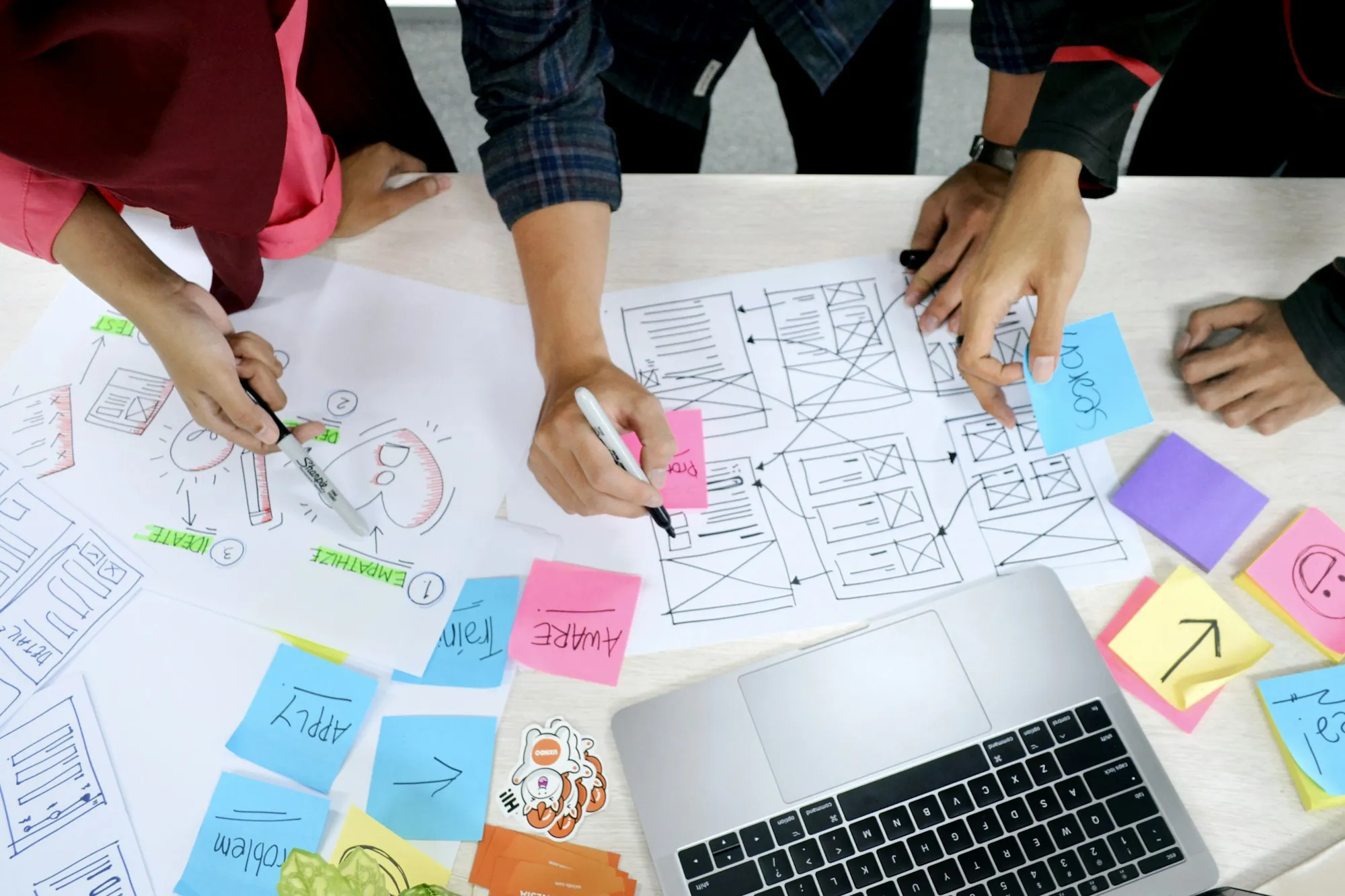 Team sketching website wireframes with sticky notes