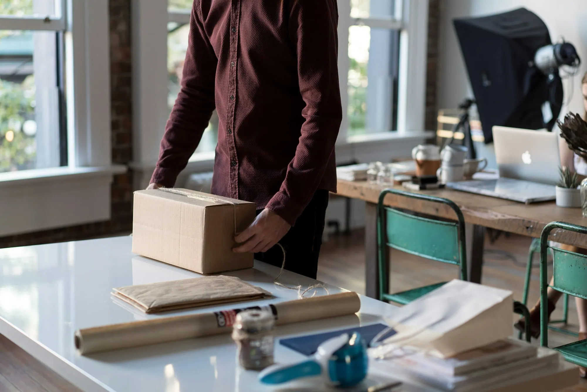 Person packing a cardboard parcel for shipping
