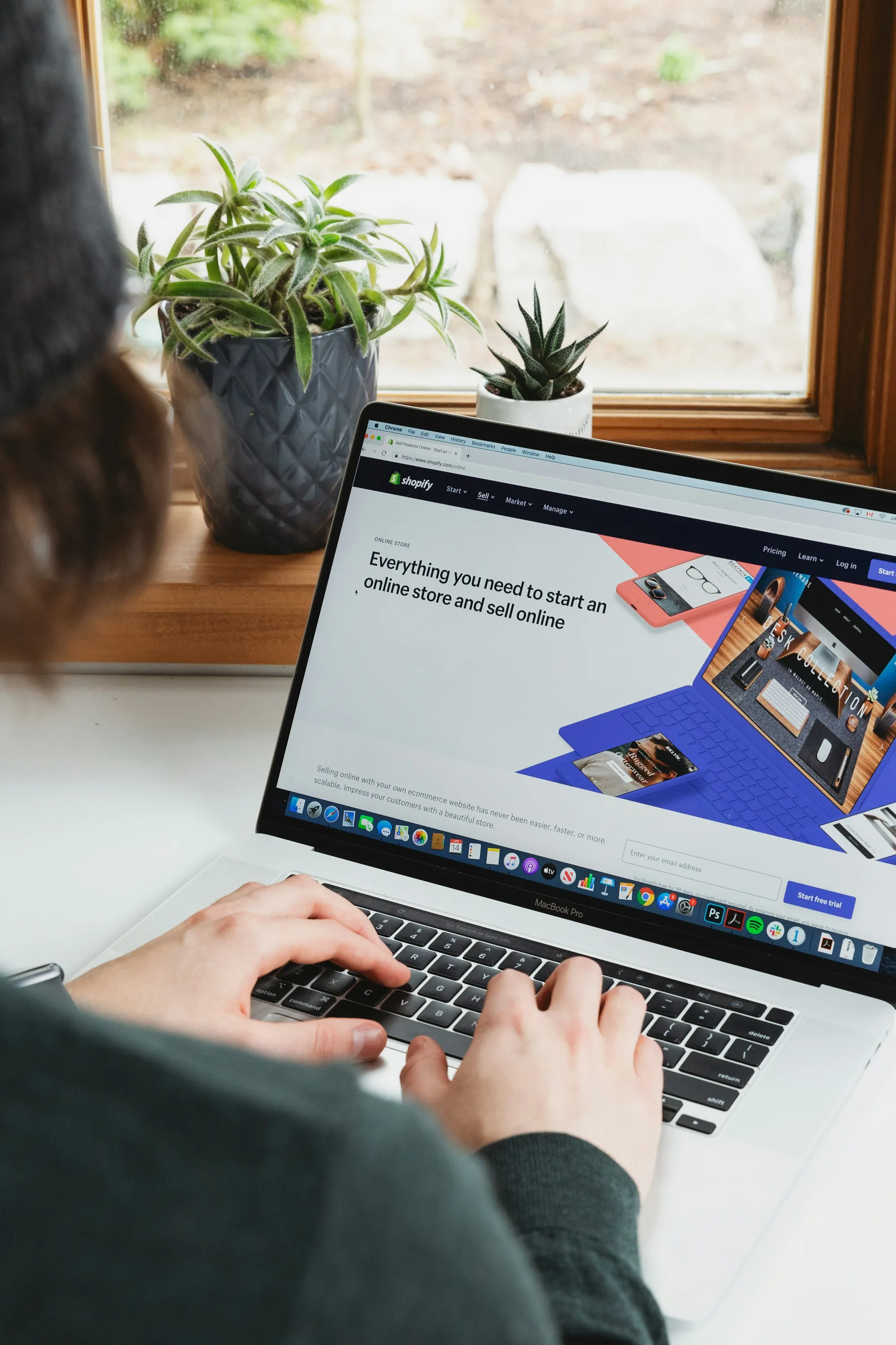 Person browsing a website on a laptop at a wooden desk